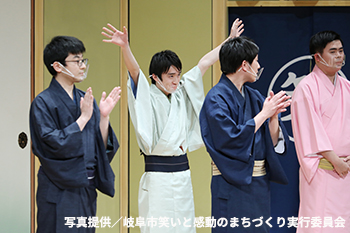 審査員特別賞に選出され、手を挙げて喜ぶ芝田さんと祝福する他大学の落語家
