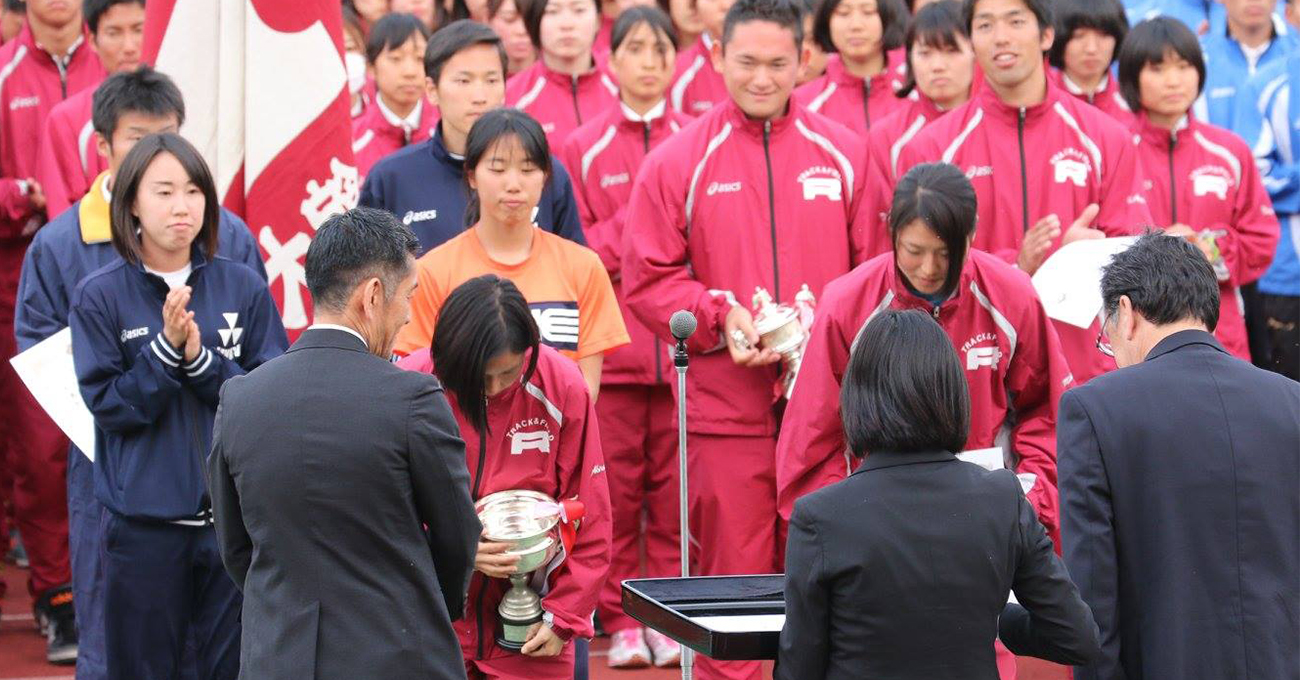 優勝トロフィーを手にする男女陸上競技部の代表