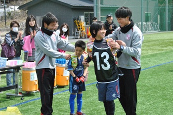 リーグ戦の優勝チームに、賞品の手づくりお菓子リュックを贈呈する濱田さん