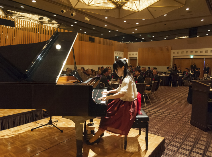 式典のオープニングでピアノを演奏する川崎円馨さん