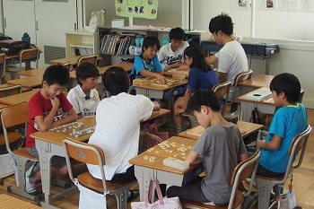 4人の小学生と同時に対戦する将棋研究会の山本将太郎さん（生命科学部4回生）