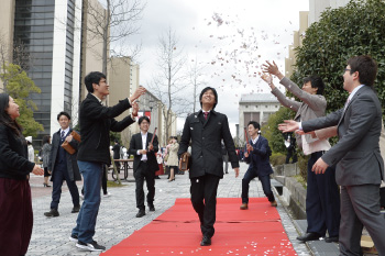 紙吹雪で祝福を受ける卒業生