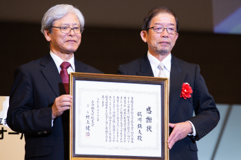 立命館大学校友会初代会長の故・畝川鎮夫氏への感謝状贈呈（写真右：令孫の畝川利之様）