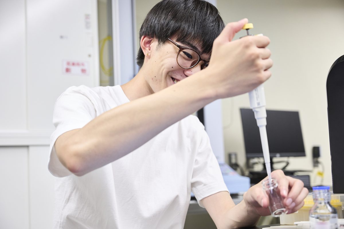 A student measuring a reagent with a pipette