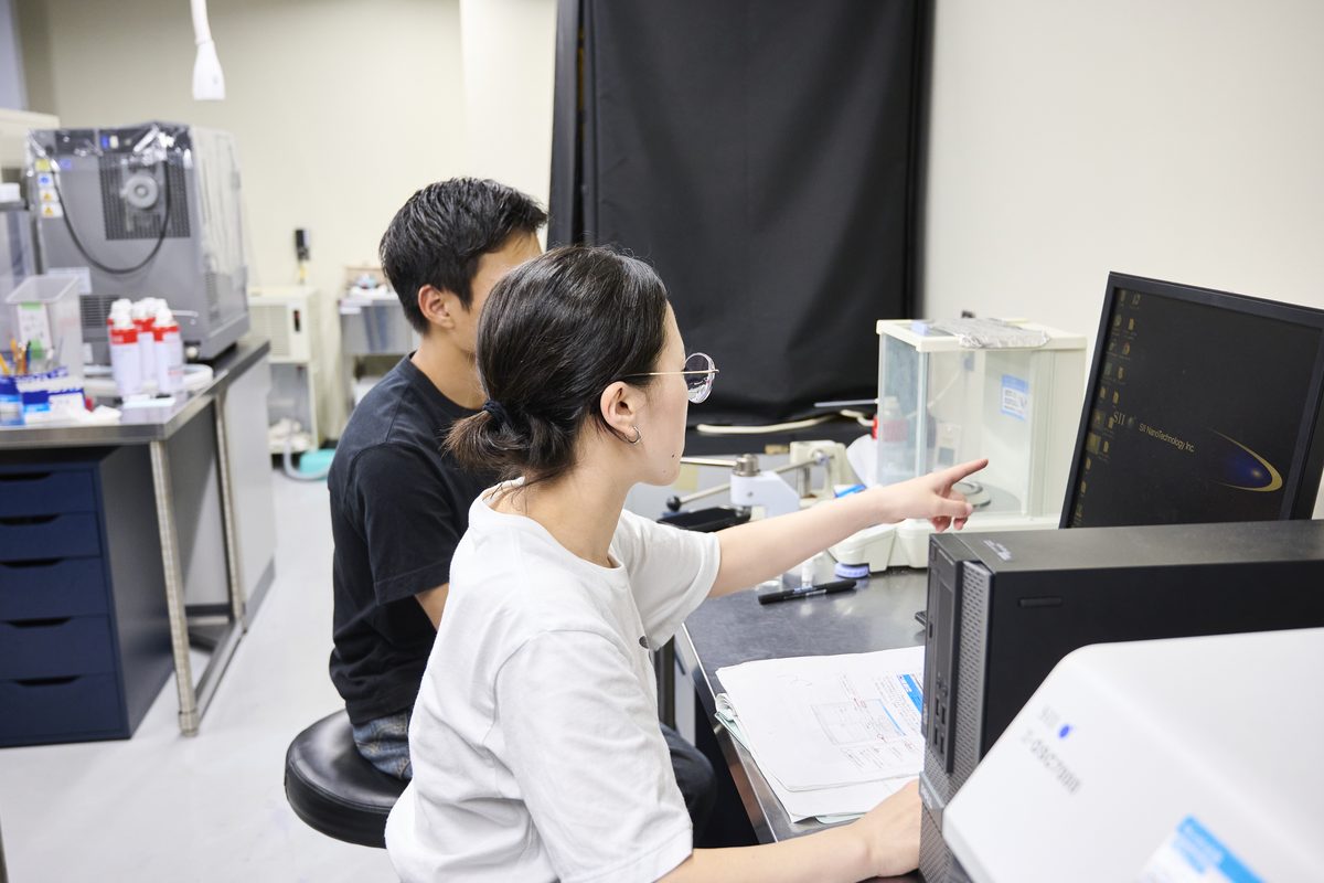 Students discussing in front of a measurement instrument