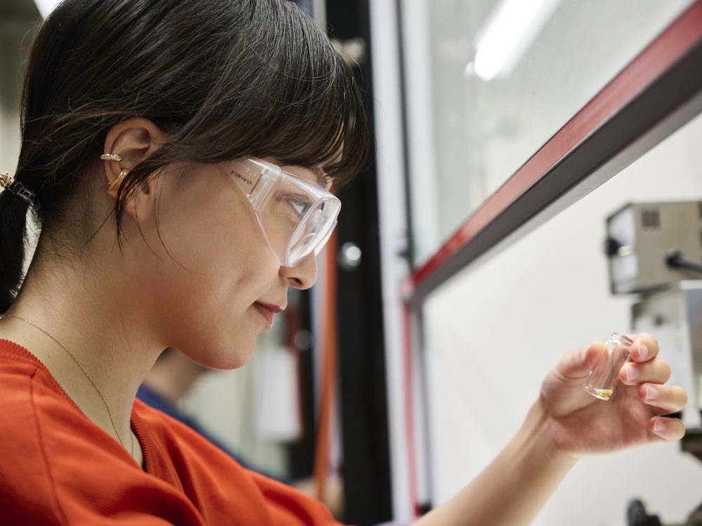 A student handling a sample vial
