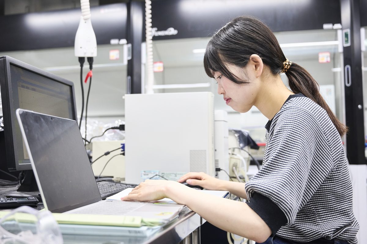A student working on calculations and analysis on a laptop