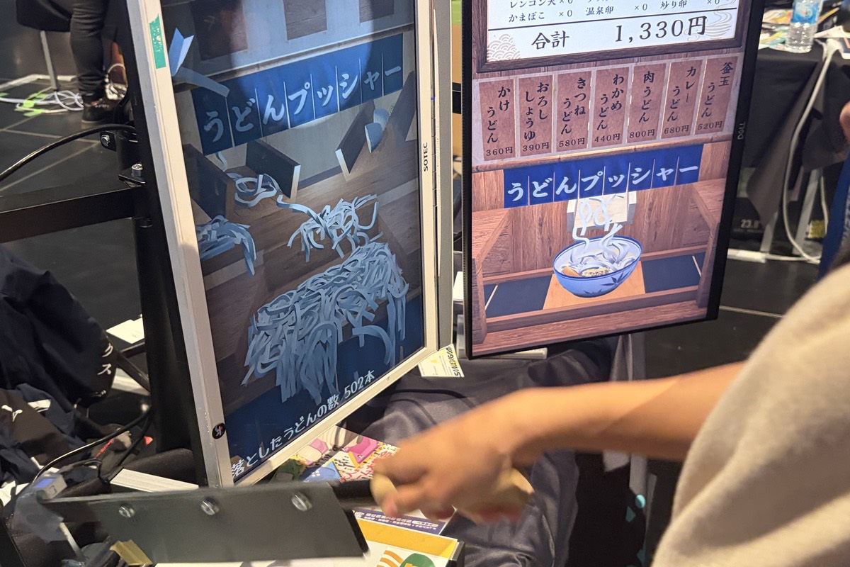 うどんがモニター上のどんぶりへ落ちる様子